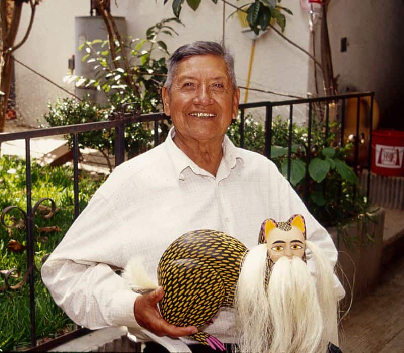 oaxaca arrtist miguel jimenez holding an alebrije