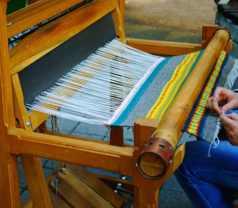 man making a rug on a loom in oaxaca mexico