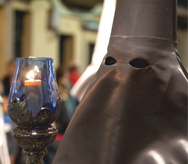hooded figure during procession of parade in oaxaca mexico