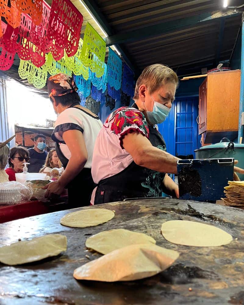 woman cooking on a comal in oaxaca mexico