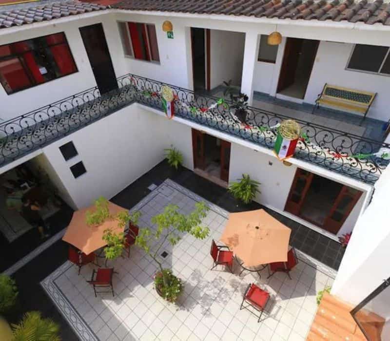 top view of Cielo Rojo Hostel and its outdoor area with cairs and tables with umbrellas