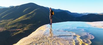 tourist standing on the hierve el agua pool