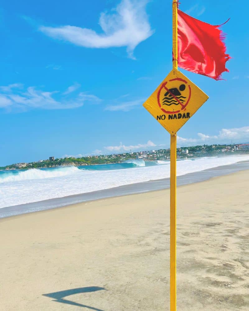 sign saying "no swimming" at playa zicatela puerto escondido